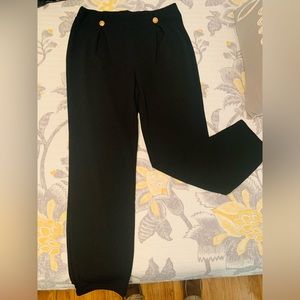 Elastic pleated black legging pants with gold buttons.